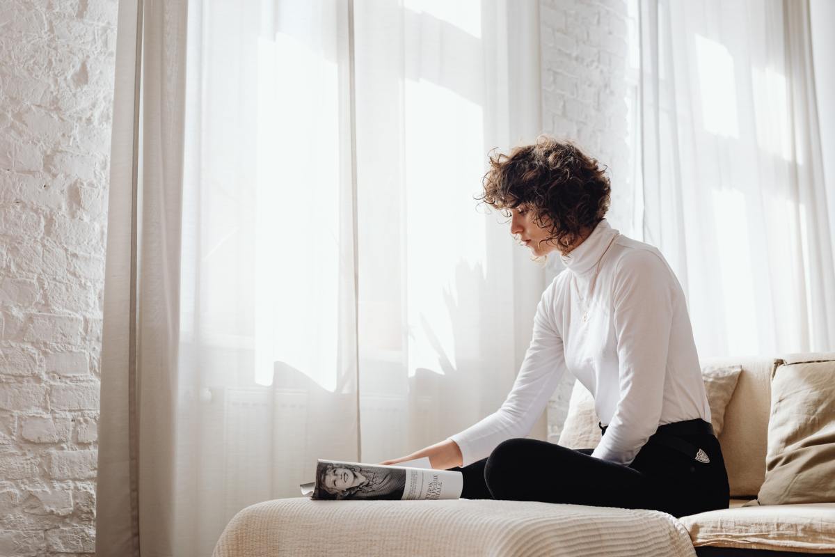 Woman sitting on a sofa reading a magazine